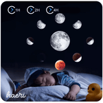 Child sleeping peacefully under rotating moon phase night light projection with timer settings and rubber duck toy.