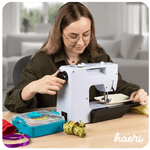 Woman using UKICRA UFR-738A sewing machine at home sewing station with accessories.