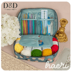 Colorful yarns and crochet tools in a floral storage case, ideal for DIY enthusiasts.