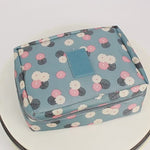 Stylish travel bag featuring a floral pattern in pastel colors, perfect for organizing essentials on the go.